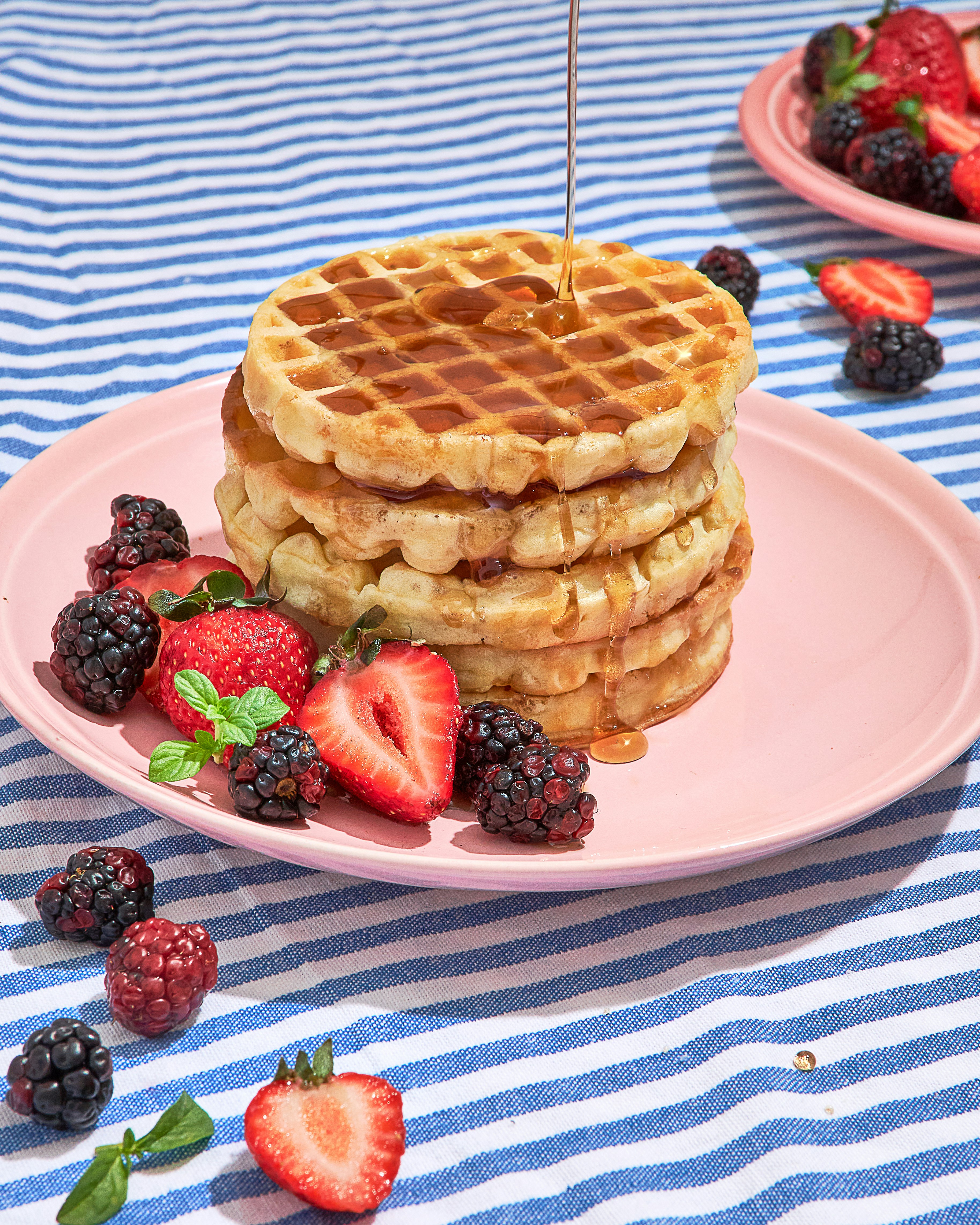 waffle with strawberry on pink ceramic plate